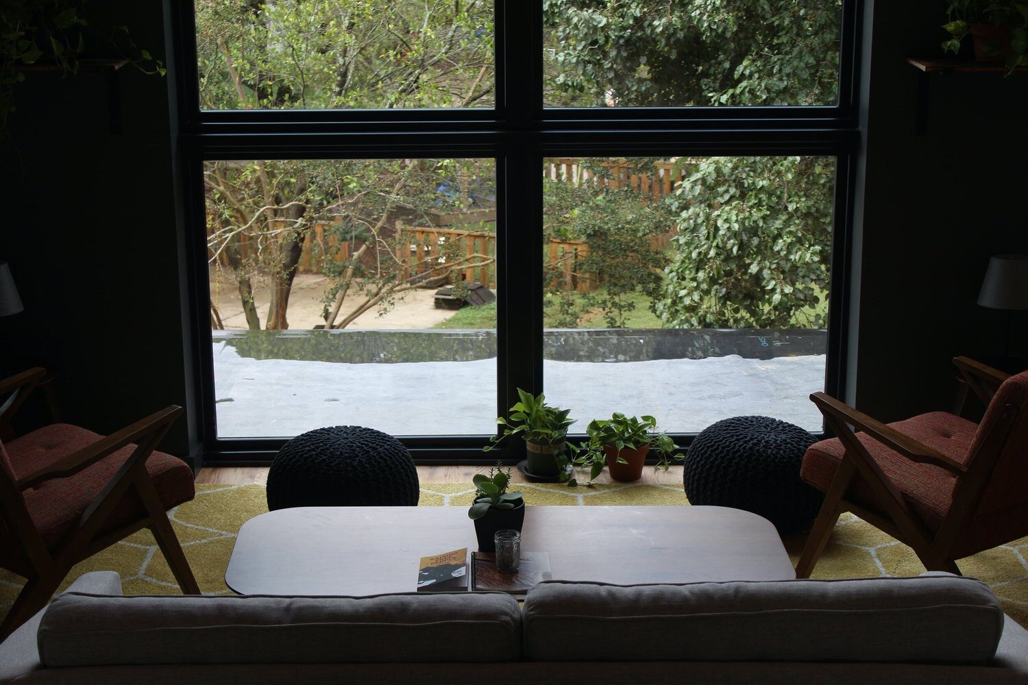 Lounge chairs facing a big window onto the trees