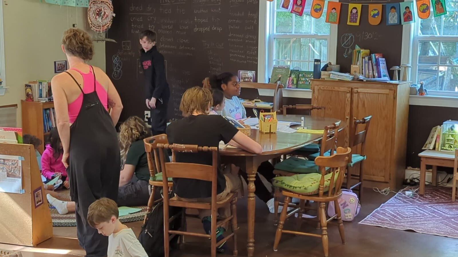 Kids working at tables in the schoolhouse